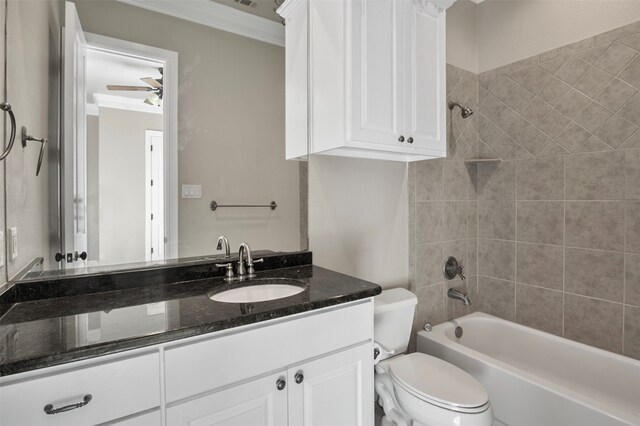 full bathroom with ornamental molding, vanity, toilet, tiled shower / bath, and ceiling fan