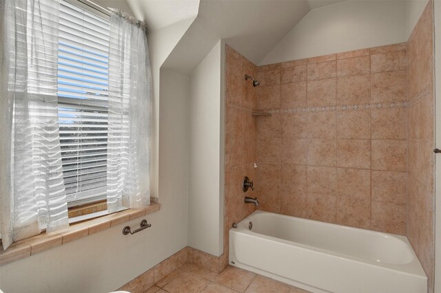 bathroom featuring tiled shower / bath combo, tile patterned floors, and vaulted ceiling