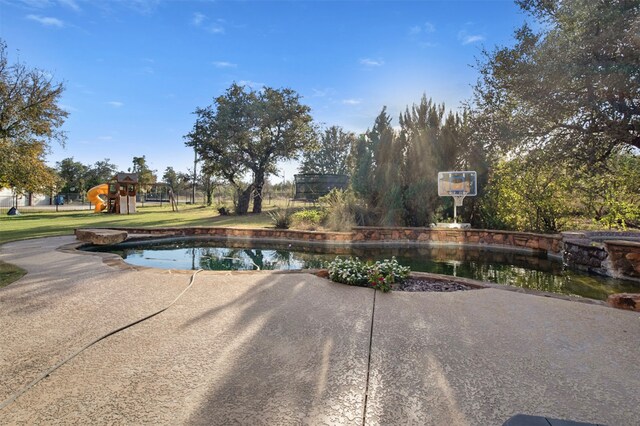 view of pool with a playground and a yard