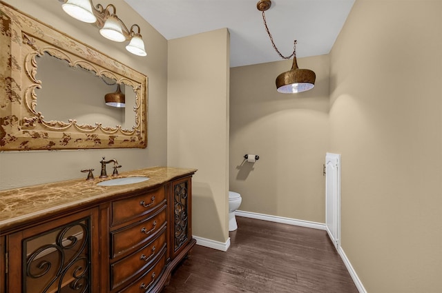 bathroom featuring wood-type flooring, vanity, and toilet