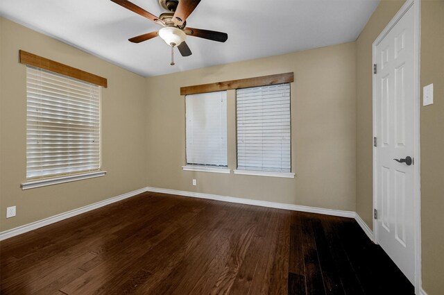 unfurnished room featuring dark wood-type flooring and ceiling fan