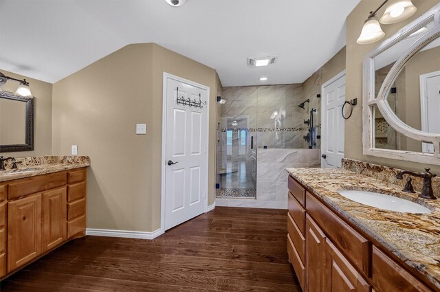 bathroom featuring walk in shower, hardwood / wood-style floors, and vanity