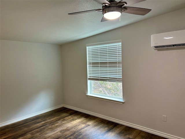 empty room featuring ceiling fan, vaulted ceiling, a wall mounted AC, and dark hardwood / wood-style flooring