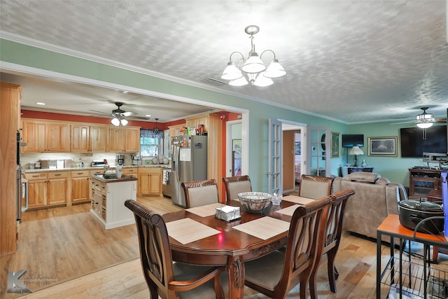 dining area featuring a textured ceiling, ceiling fan with notable chandelier, ornamental molding, and light hardwood / wood-style flooring