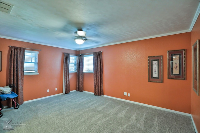 unfurnished room featuring carpet floors, ceiling fan, and crown molding