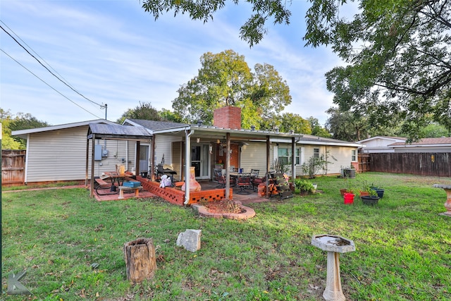 back of property with a lawn and a patio