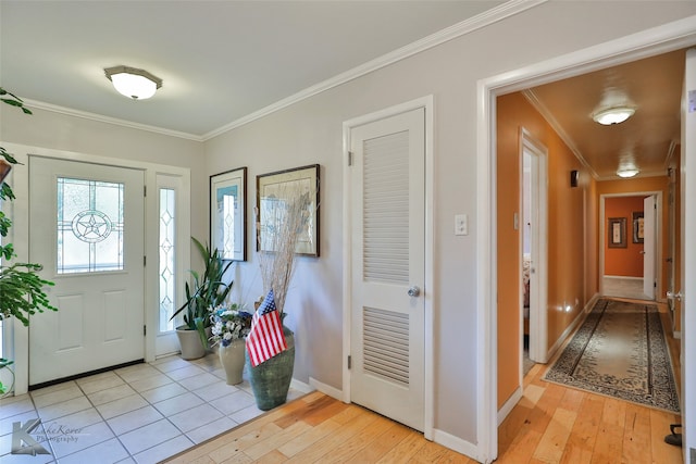 foyer with light wood-type flooring and crown molding