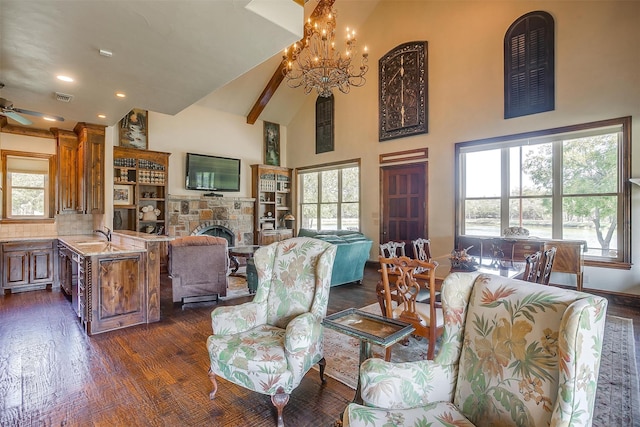 living room featuring a stone fireplace, dark hardwood / wood-style floors, ceiling fan with notable chandelier, and high vaulted ceiling