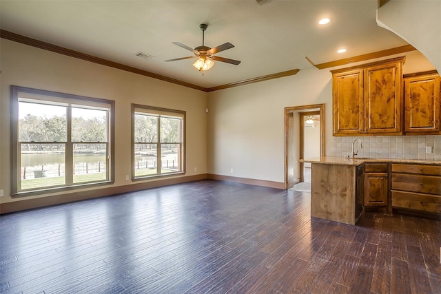 kitchen featuring crown molding, dark hardwood / wood-style flooring, sink, decorative backsplash, and ceiling fan