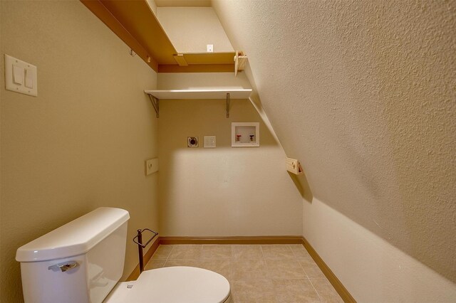 bathroom with toilet and tile patterned flooring