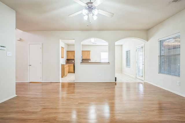 unfurnished living room with light wood-type flooring and ceiling fan