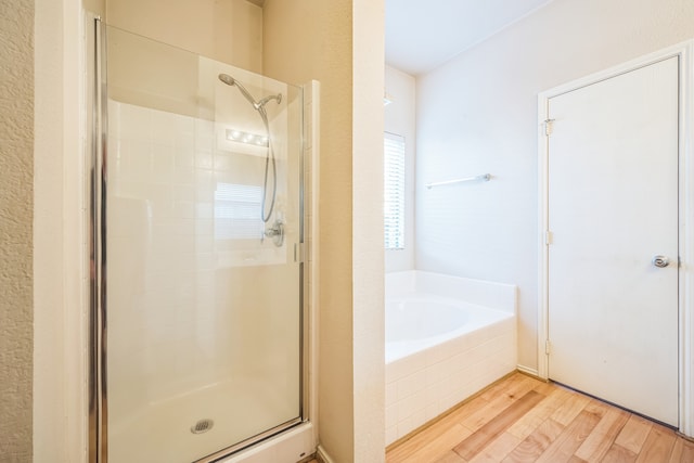 bathroom with shower with separate bathtub and hardwood / wood-style floors