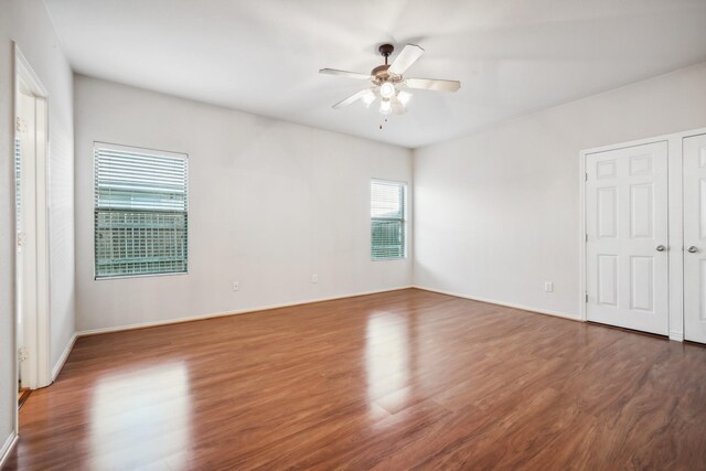 spare room with dark wood-type flooring and ceiling fan