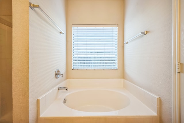 bathroom featuring a relaxing tiled tub