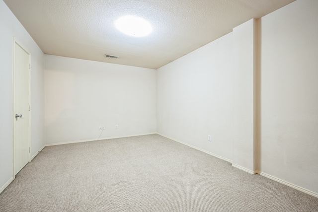 empty room with a textured ceiling and carpet floors