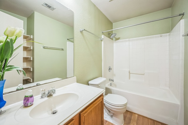 full bathroom with toilet, a textured ceiling, hardwood / wood-style flooring, vanity, and tub / shower combination