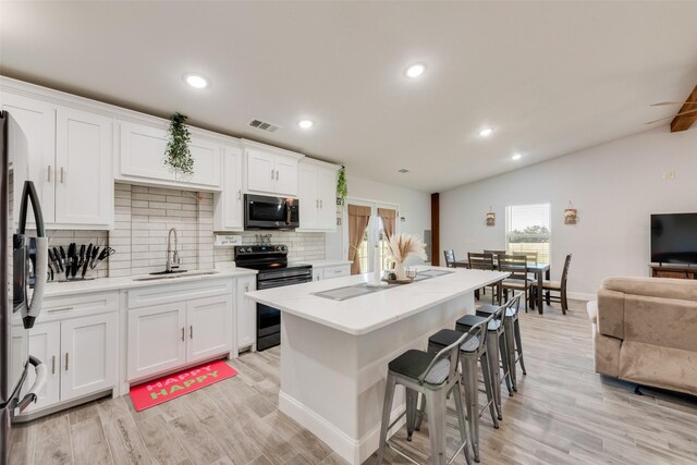 kitchen with white cabinetry, sink, appliances with stainless steel finishes, and light hardwood / wood-style flooring