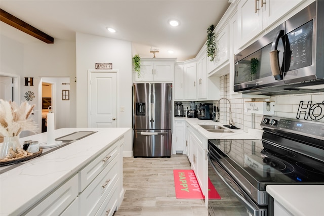 kitchen with backsplash, stainless steel appliances, sink, light hardwood / wood-style flooring, and white cabinets