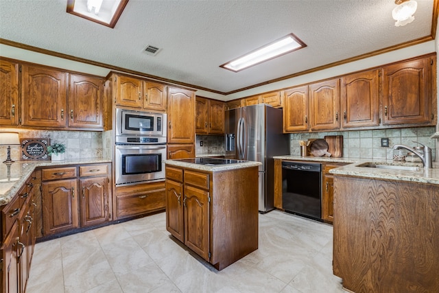 kitchen with sink, crown molding, a kitchen island, light stone countertops, and black appliances