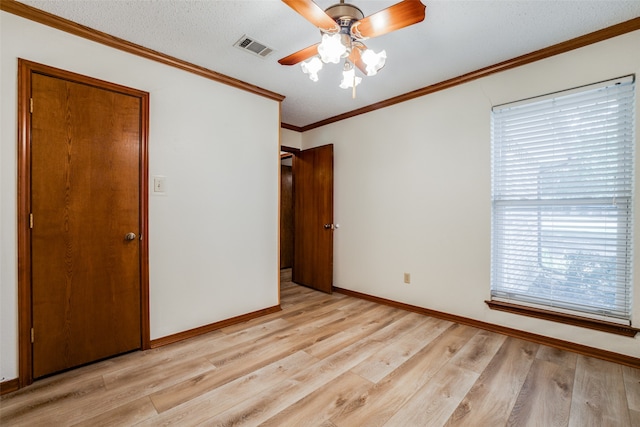 unfurnished bedroom with light hardwood / wood-style floors, ceiling fan, a textured ceiling, crown molding, and a closet