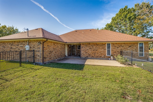 back of house featuring a lawn and a patio