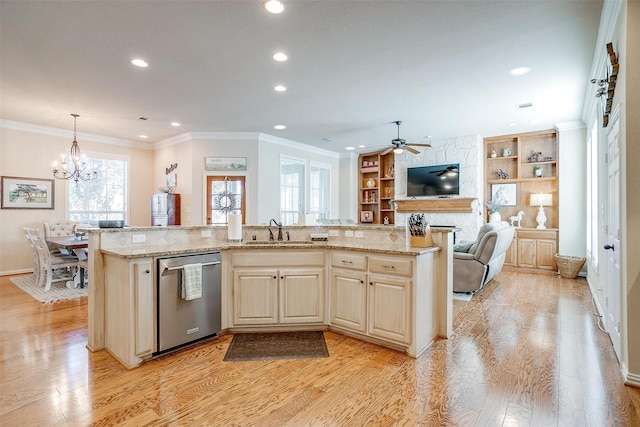 kitchen with sink, stainless steel dishwasher, hanging light fixtures, and an island with sink