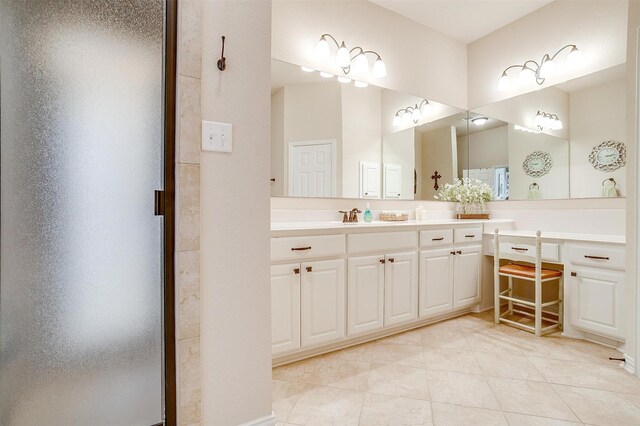 full bath with a stall shower, vanity, and tile patterned floors