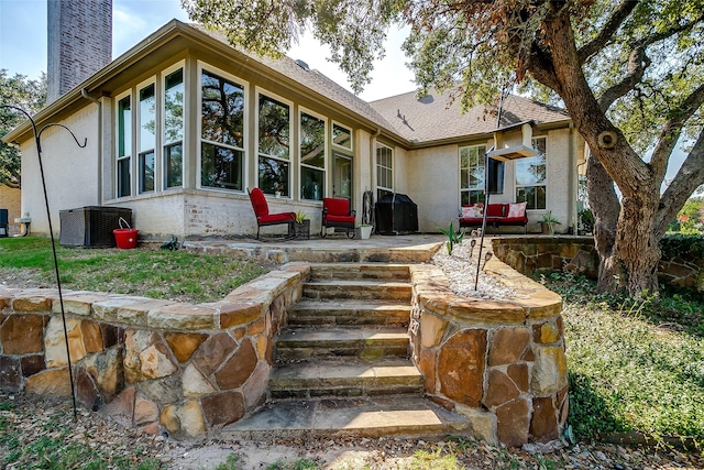 rear view of property with a patio area, a chimney, and central AC unit