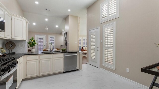 kitchen featuring a wealth of natural light, sink, kitchen peninsula, white cabinets, and appliances with stainless steel finishes