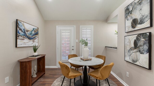 dining space with lofted ceiling and dark wood-type flooring