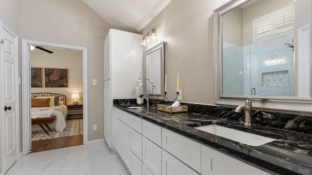 bathroom featuring vanity, a shower with door, and vaulted ceiling