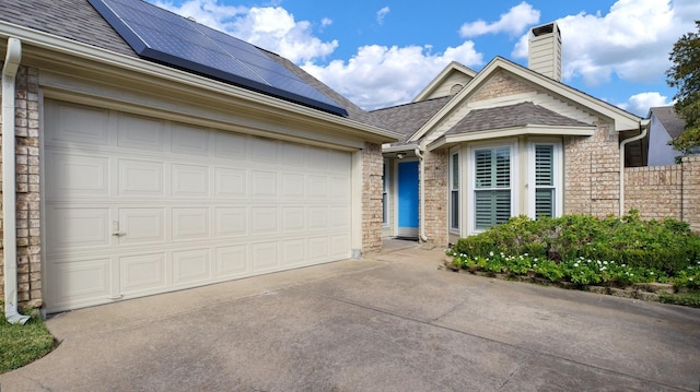 view of front of property featuring solar panels and a garage