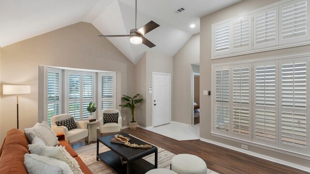 living room featuring ceiling fan, high vaulted ceiling, and dark wood-type flooring