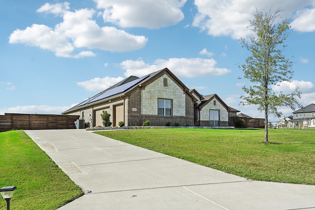 view of front facade with a front yard and solar panels