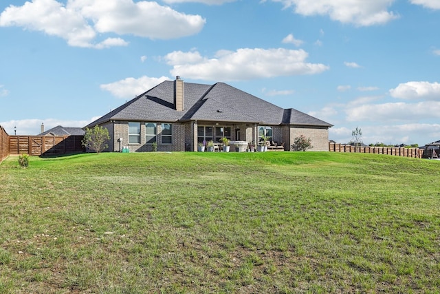 rear view of house featuring a yard