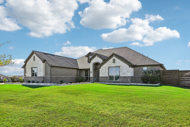 french country inspired facade with a front yard