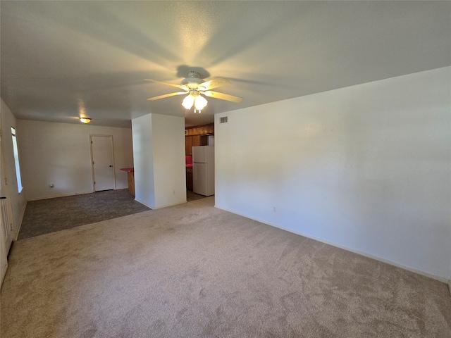 spare room with light colored carpet and ceiling fan