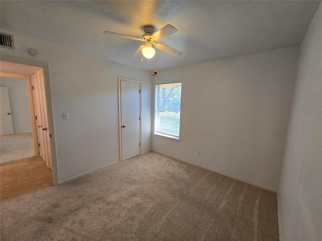 unfurnished bedroom featuring a closet, light carpet, and ceiling fan