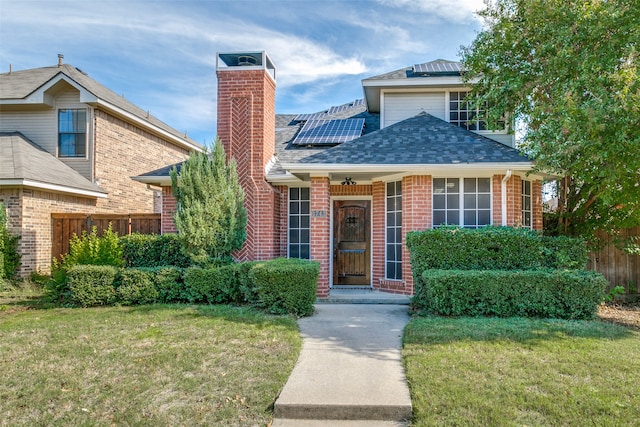 view of front facade with solar panels and a front yard