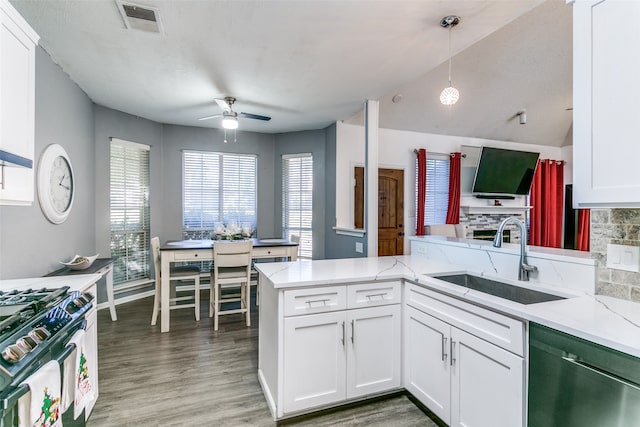 kitchen featuring white cabinetry, appliances with stainless steel finishes, hanging light fixtures, sink, and kitchen peninsula