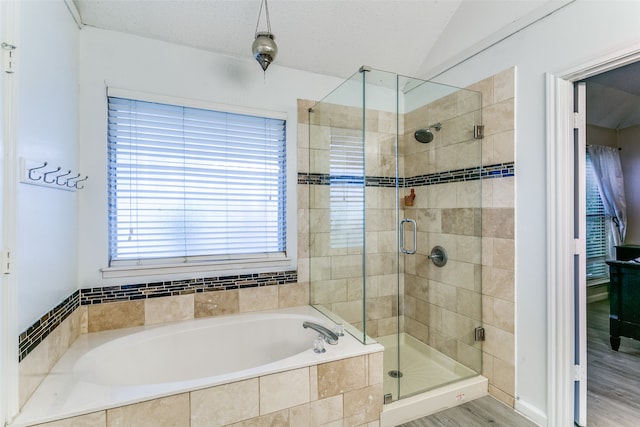 bathroom featuring a textured ceiling, hardwood / wood-style flooring, and independent shower and bath