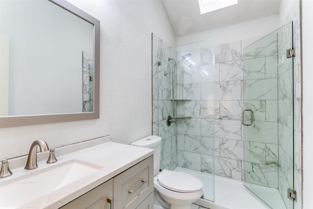 bathroom featuring vaulted ceiling with skylight, a shower with shower door, vanity, and toilet