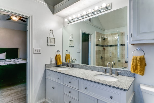 bathroom with a shower with door, crown molding, vanity, hardwood / wood-style floors, and ceiling fan