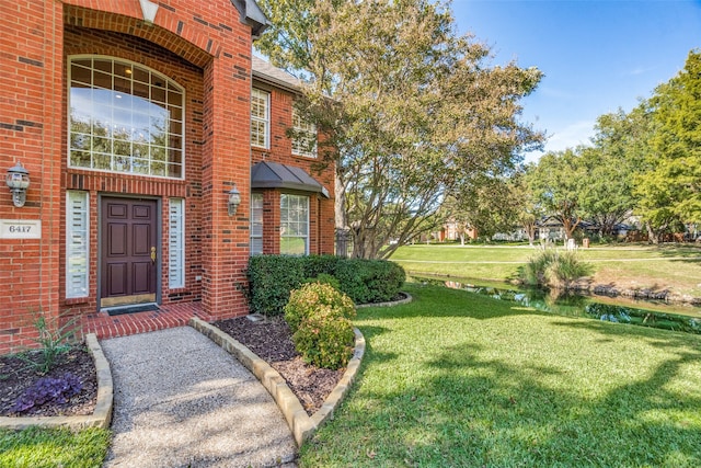 view of exterior entry with a lawn