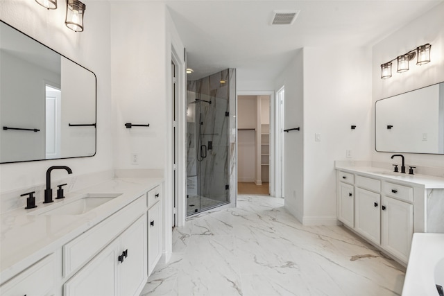 bathroom featuring a shower with door and vanity