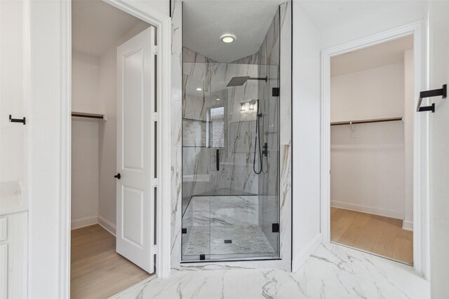 bathroom featuring hardwood / wood-style flooring and a shower with shower door