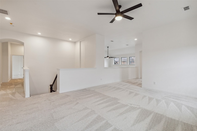 unfurnished living room with light colored carpet and ceiling fan