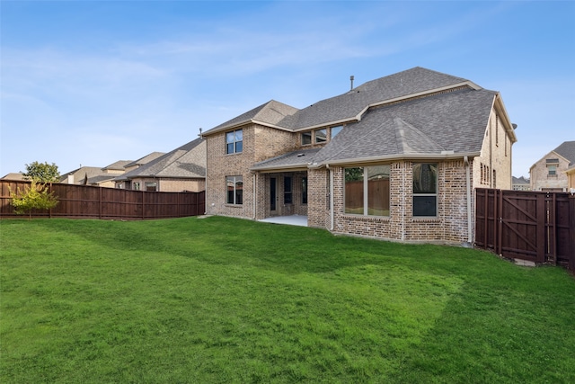 rear view of house featuring a yard and a patio area