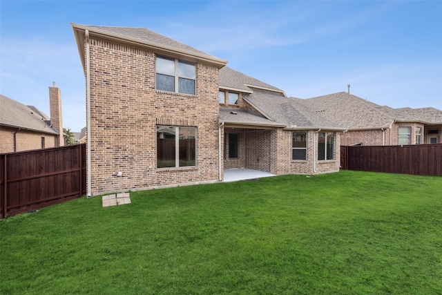 rear view of property with a yard and a patio area