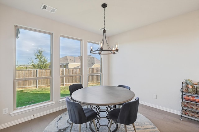 dining area with hardwood / wood-style flooring and a notable chandelier